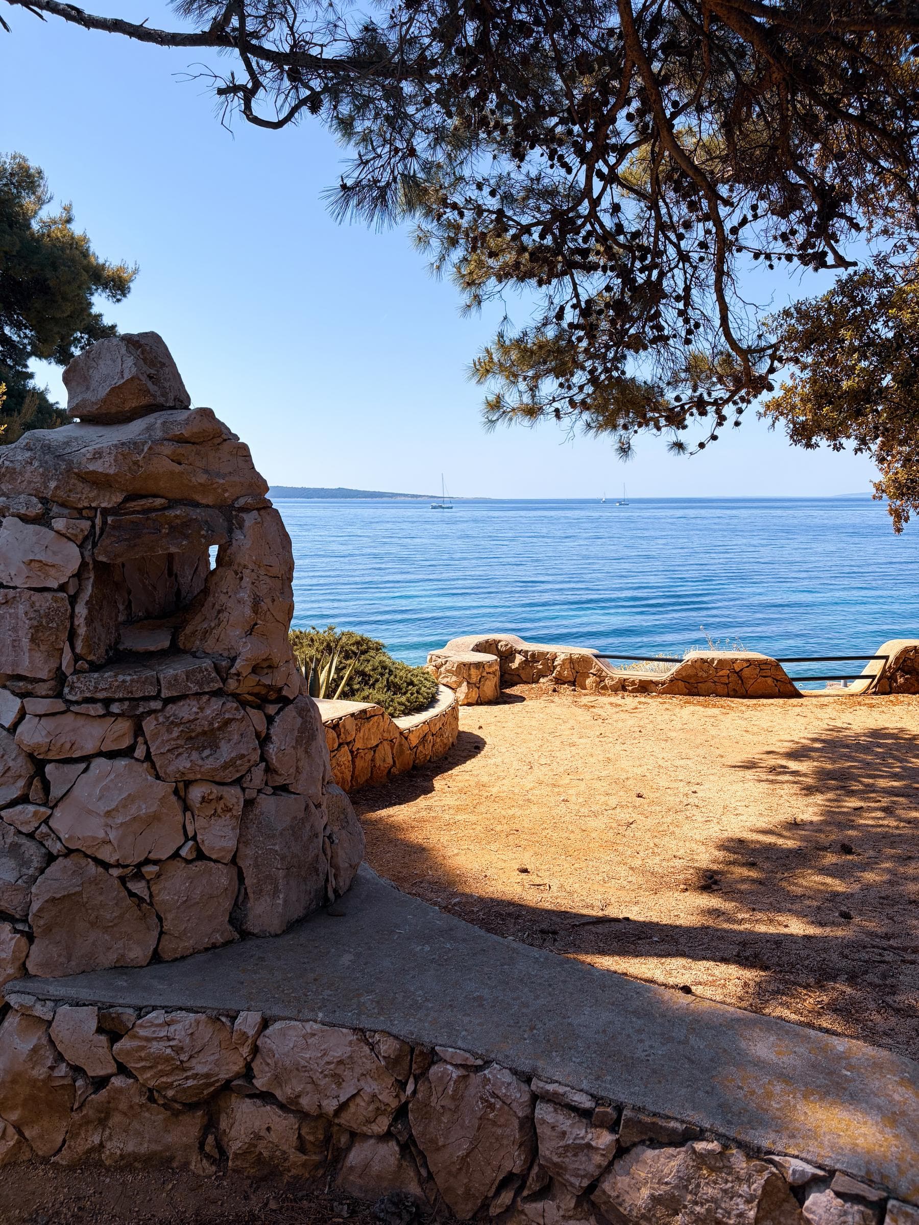 Aerial-style high-angle of a small cove with no people. Pine border.