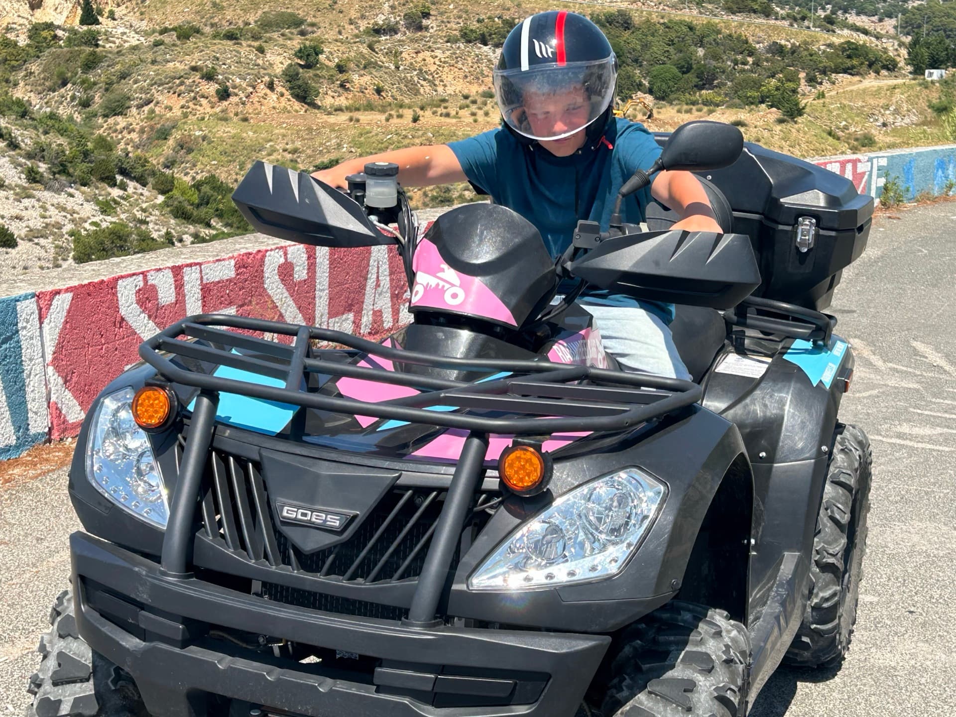 A Rab dirt track and quad-rental detail, dusty road edge, no licence plates.