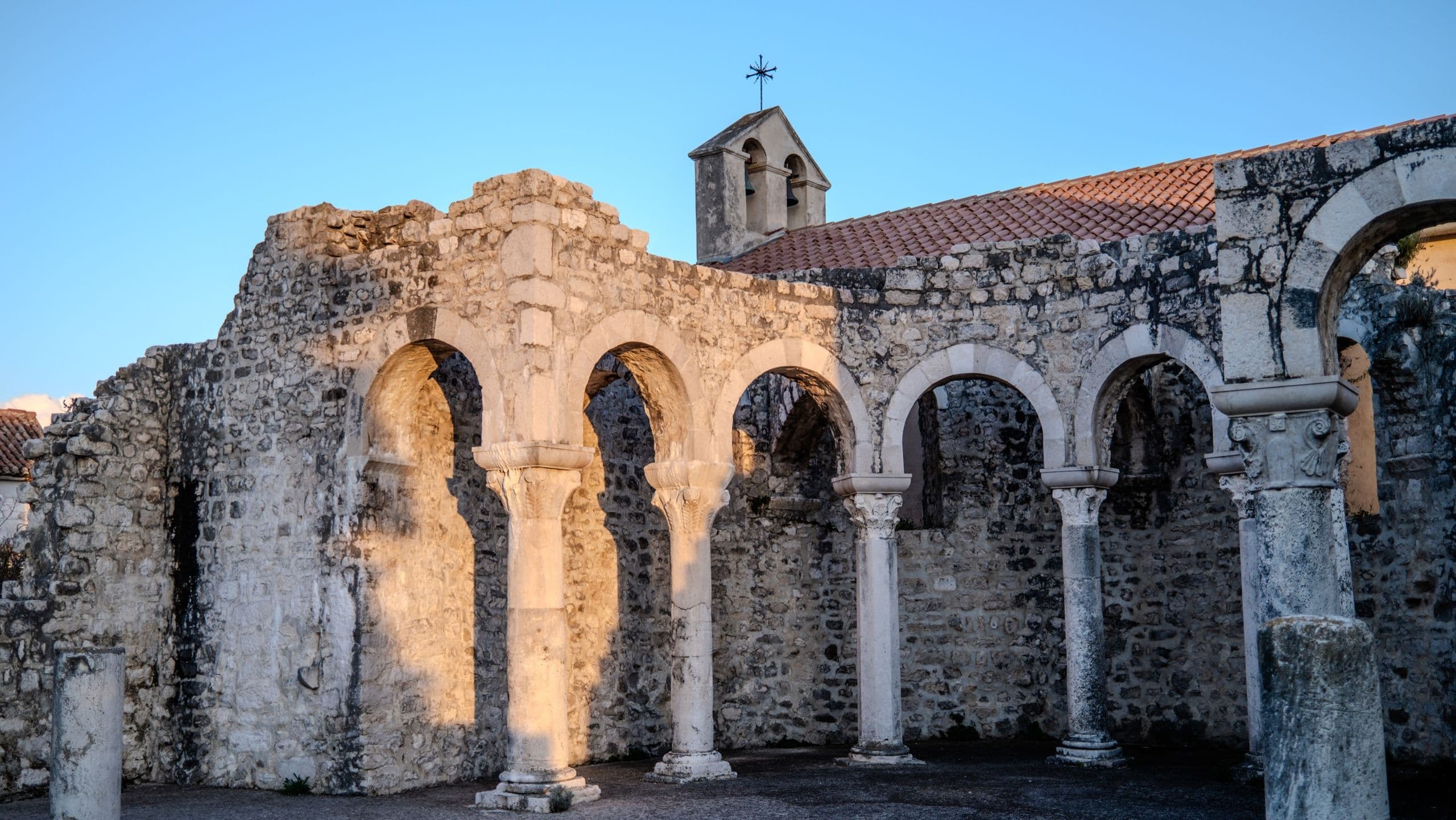A row of stone arches in the old town church ruins, warm afternoon light.