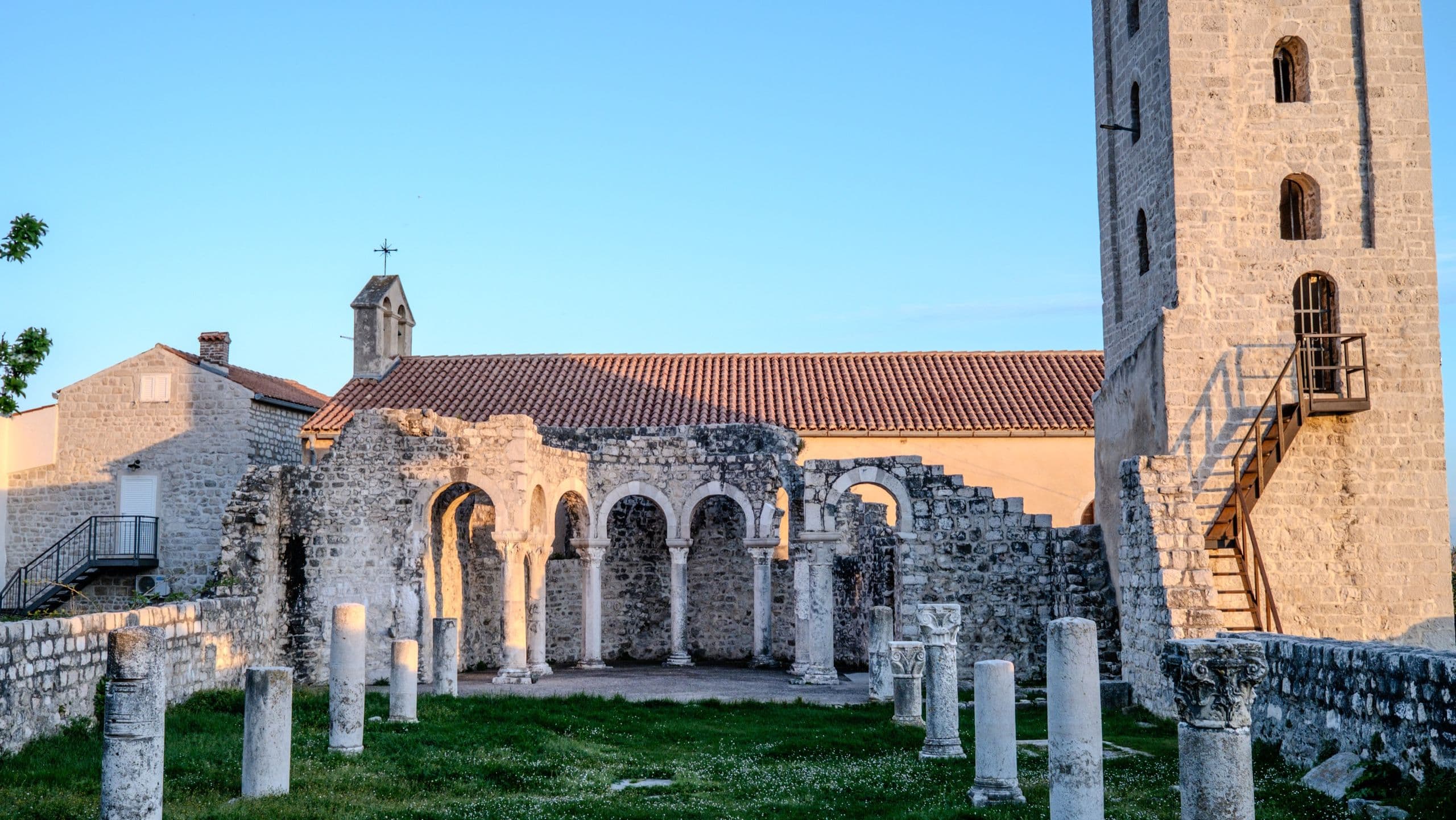 Romanesque church ruins of the old town in warm late light under a clear sky.