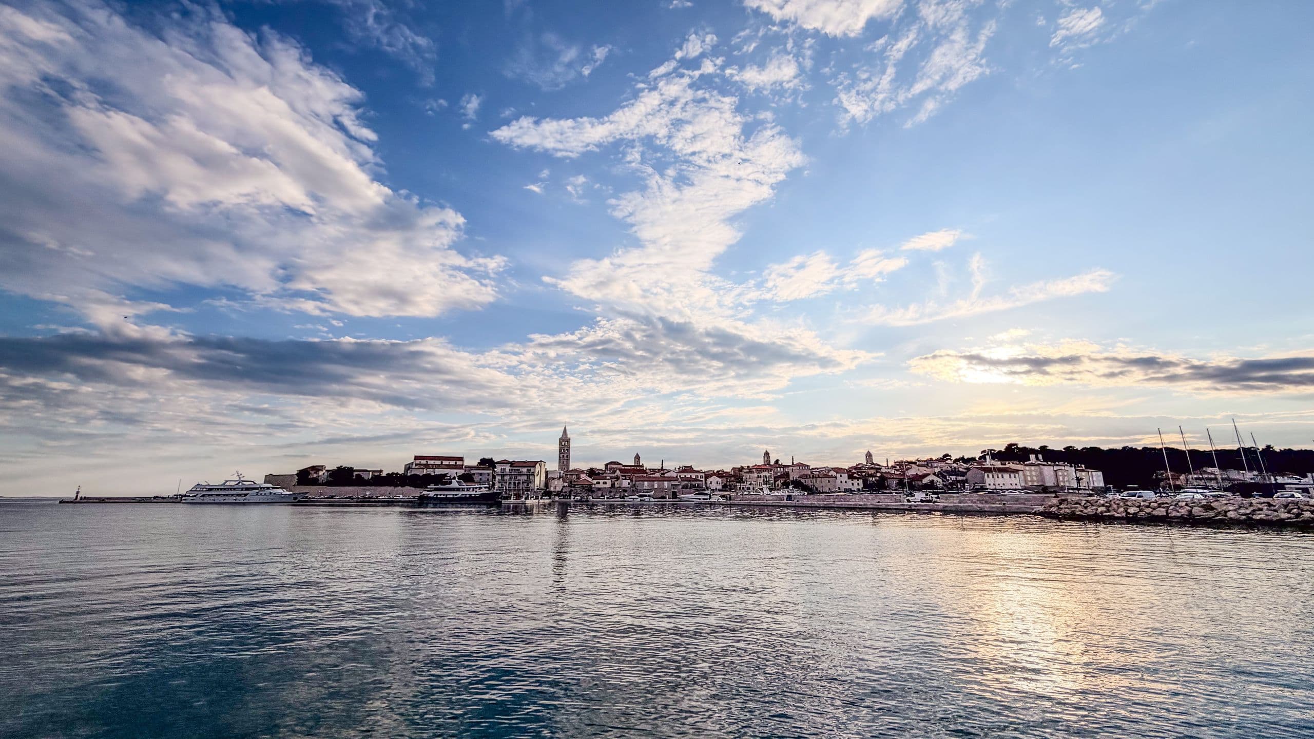 Wide panoramic view of Rab old town from the harbour.
